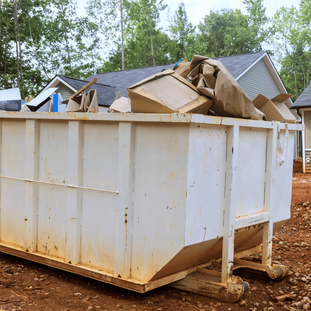 A white dumpster outside of a house