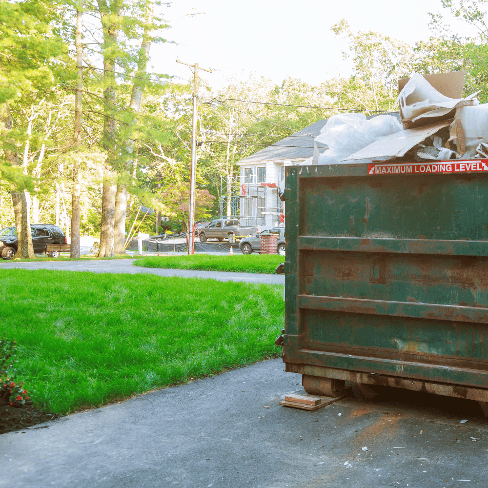 A green dumpster on a residential street
